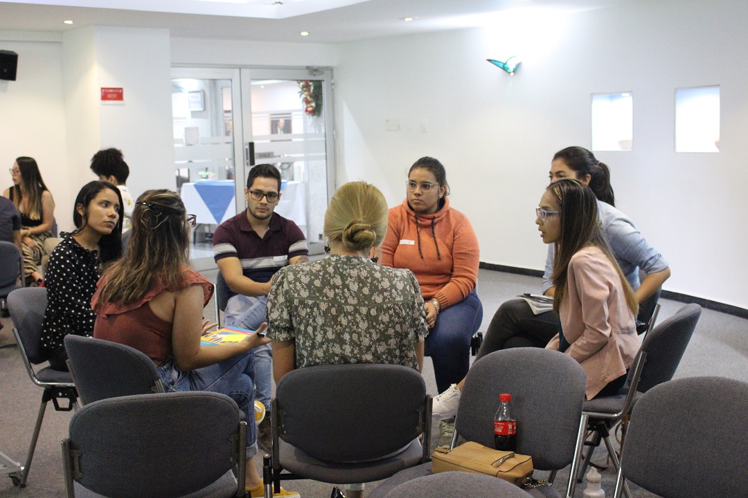 Grupo de personas sentadas en un círculo conversando