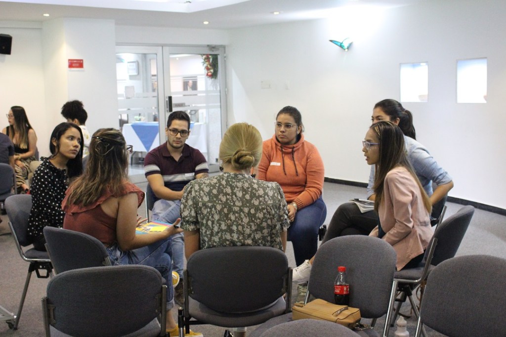 Grupo de personas sentadas en un círculo conversando