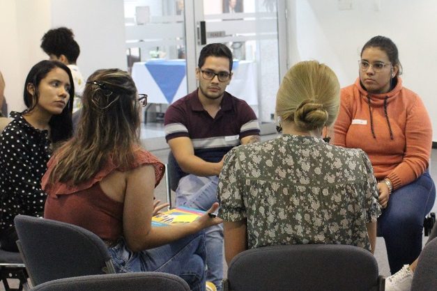 Grupo de personas sentadas en un círculo conversando